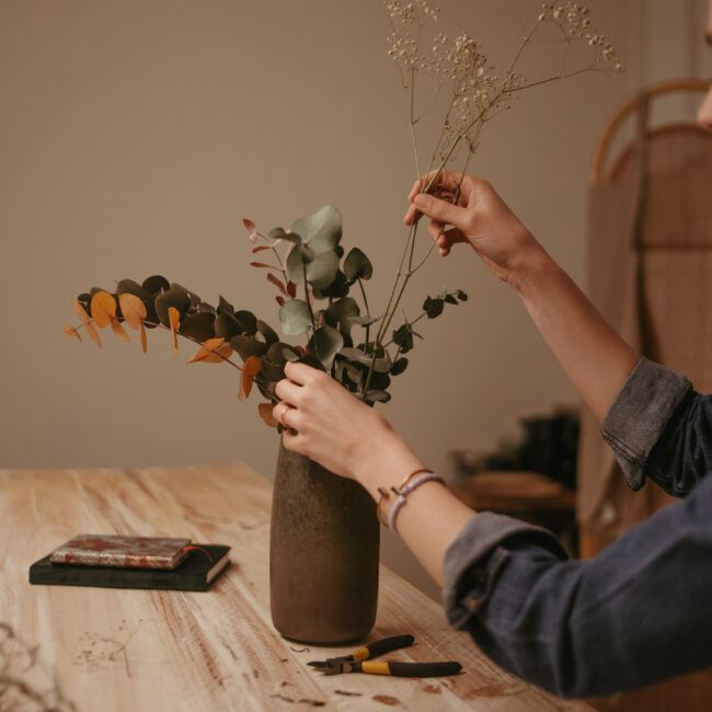 mujer colocando flores en un jarrón